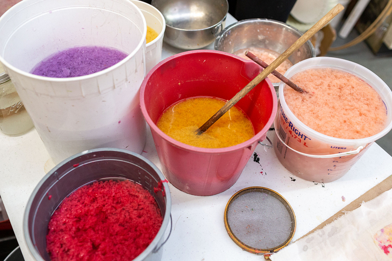 Buckets of dyed paper pulp