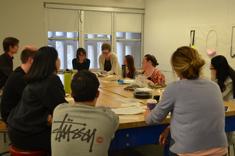 Carrie Schwier and a group of students collaborate around a table.