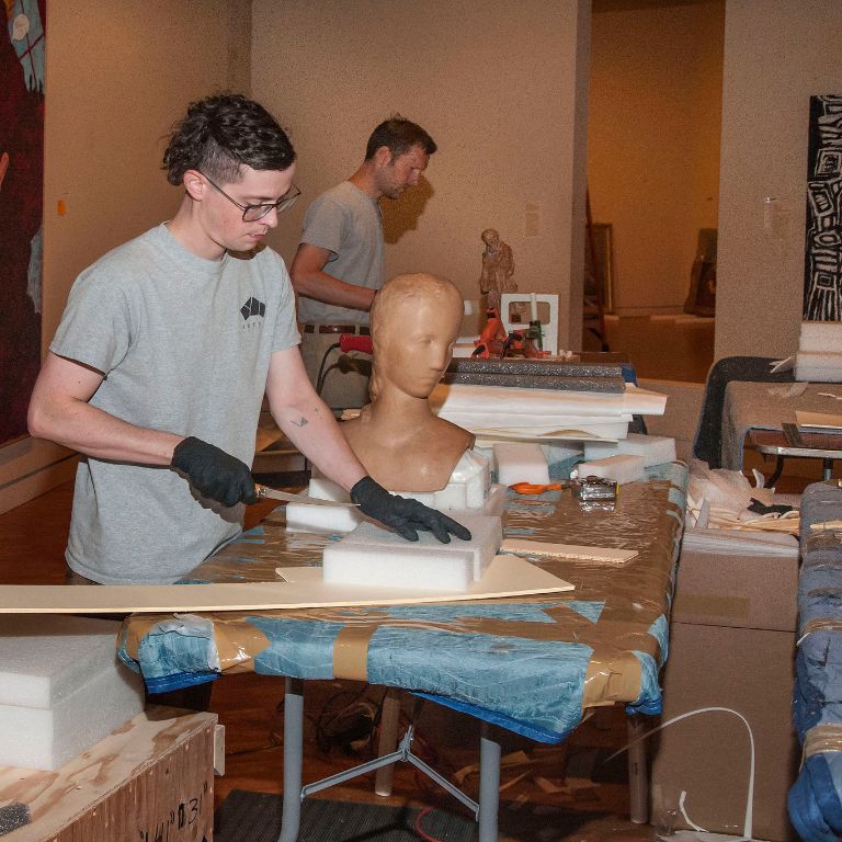 Two men pack items in the Eskenazi Museum of Art.