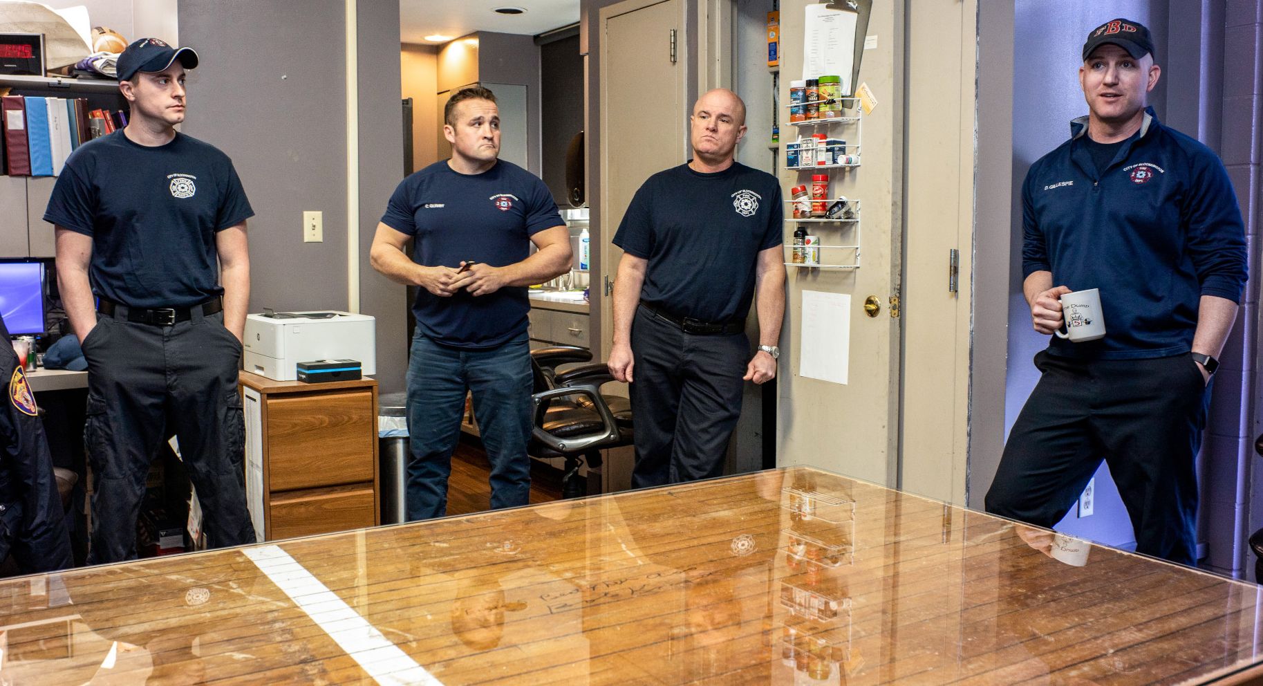Firefighters stand around their station's new table made from a section of basketball court