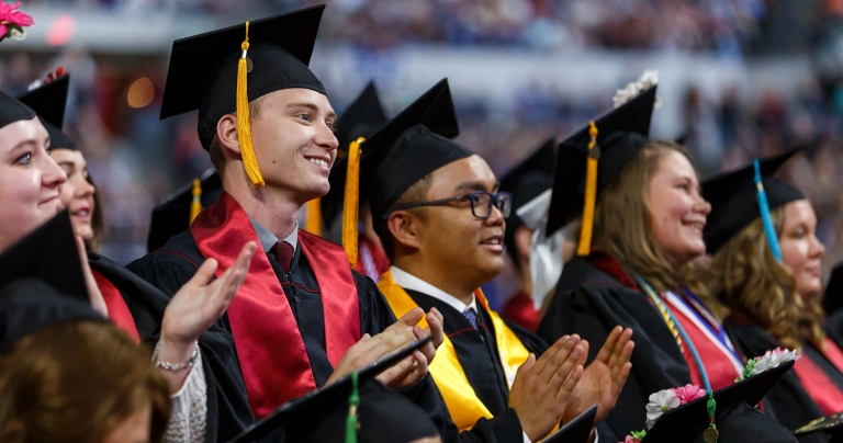 IUPUI students in caps and gowns clapping during a ceremony