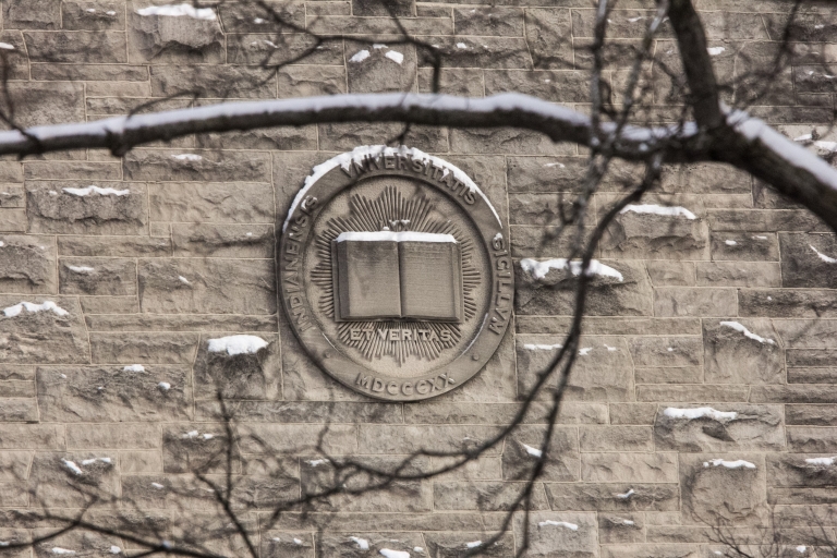 Limestone IU seal on the side of a building