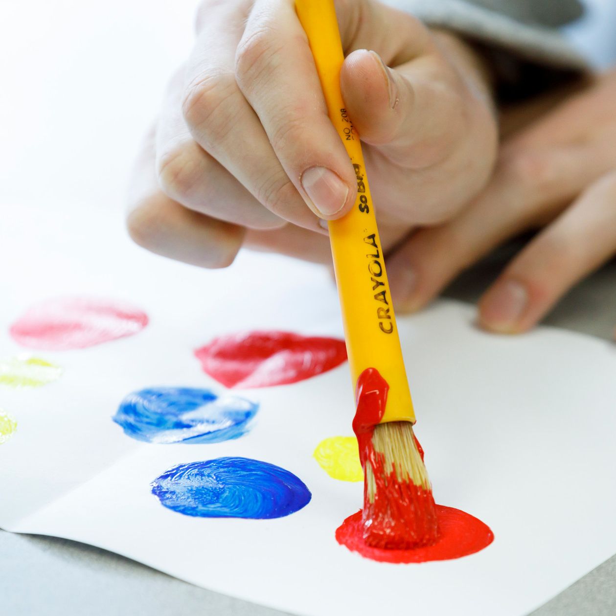 Joey Brunk paints a red dot.