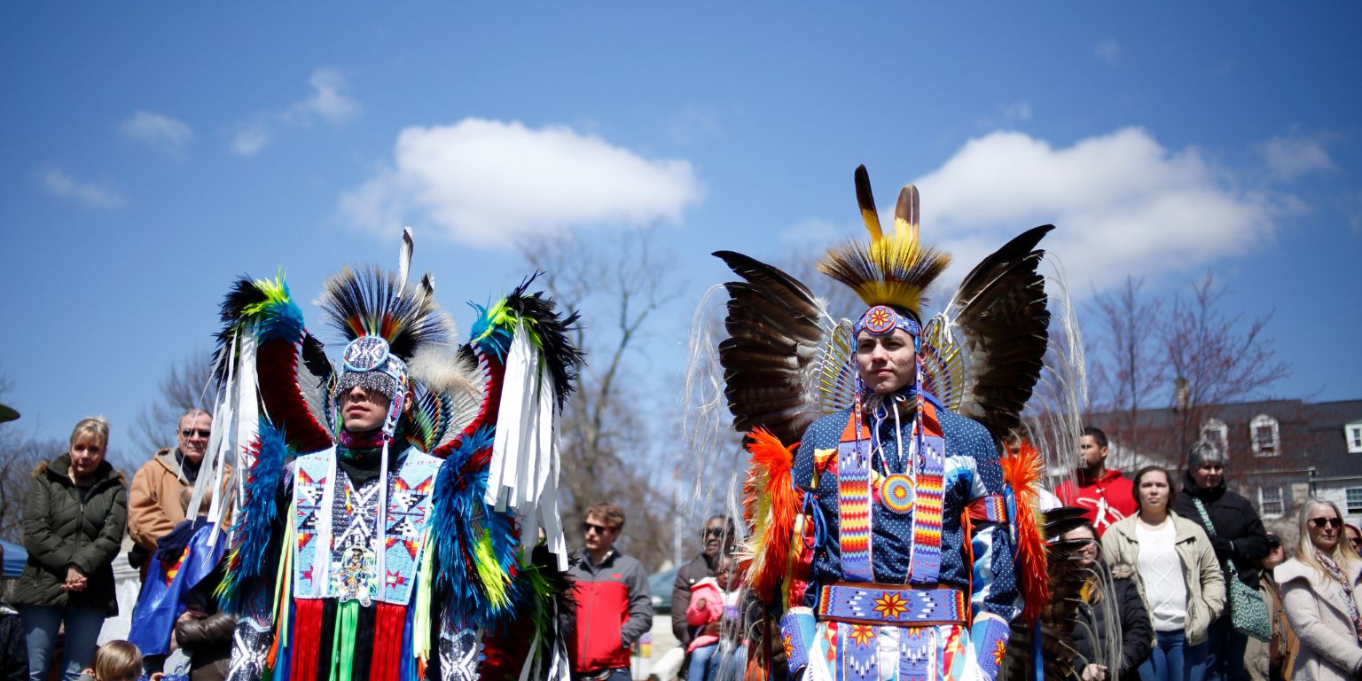 Two men wear traditional Native American attire at IU's powwow