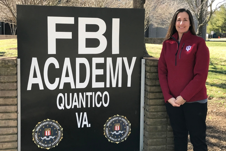 Jill Lees stands in front of a sign at the FBI National Academy
