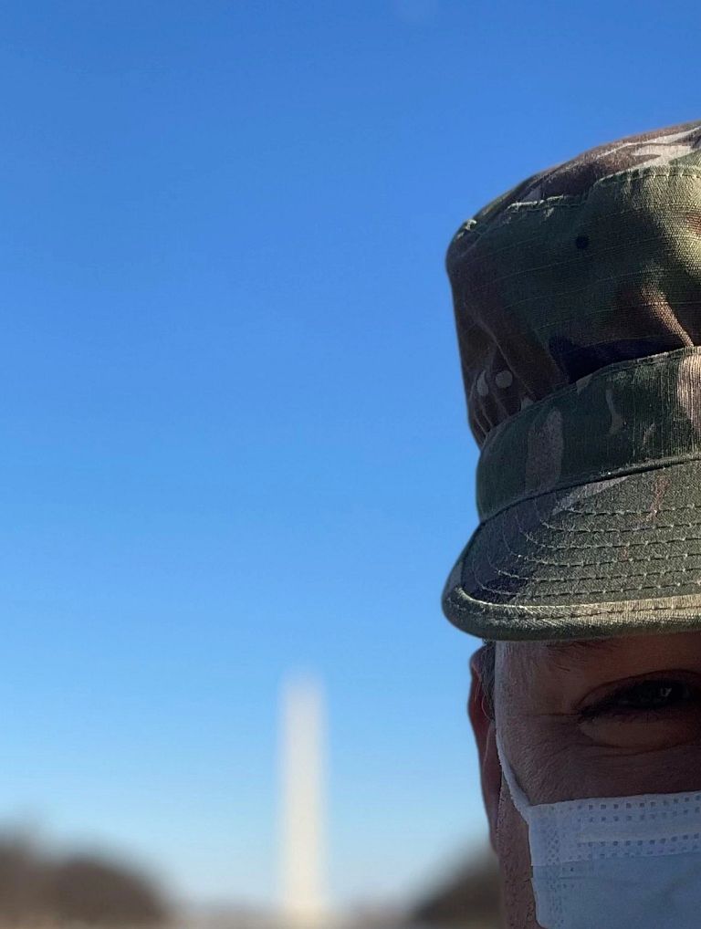 Dr. Sample wears a mask with the Washington Monument behind him
