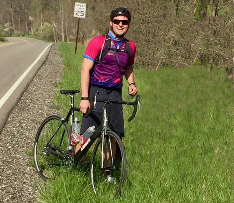 Alex Hollingsworth stands next to his bicycle.