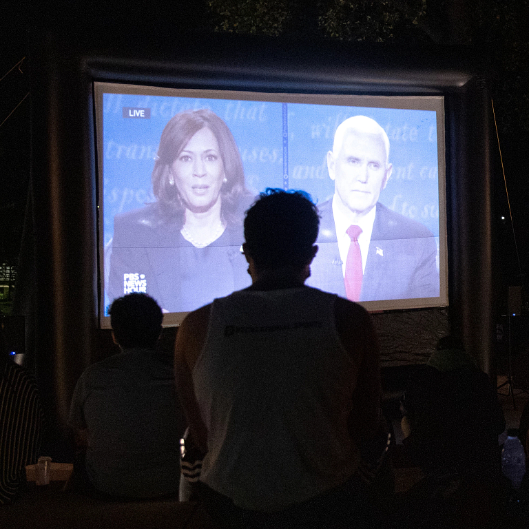 IU Bloomington students watch the 2020 vice presidential debate outdoors on a large screen