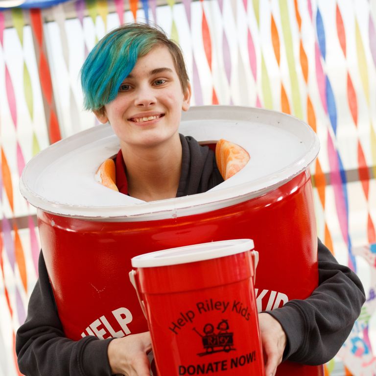 Student dressed as a red collection can collects donations.