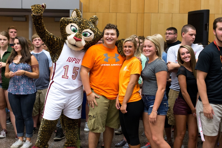 Jazzy the jaguar mascot poses with a group of students