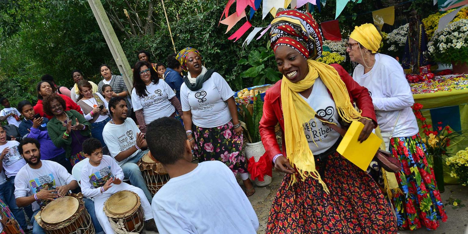 People in colorful clothing dance in the street