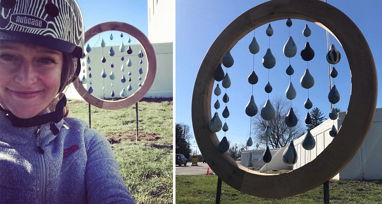 a woman poses with art she created that looks like water droplets