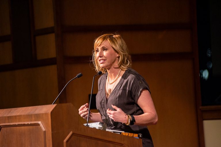 A woman speaks at a podium with a microphone.