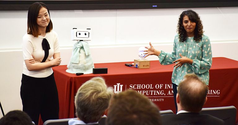 Tingyu Li and Pavithra Ramamurthy speak to judges sitting on chairs