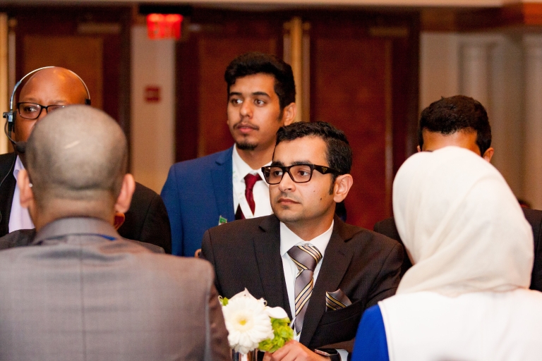 Abdullah Alzeer sits at a table during an award ceremony.