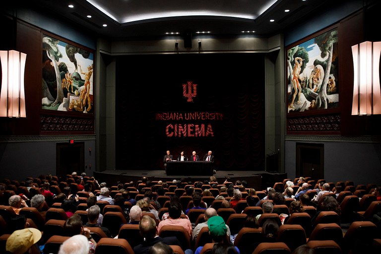 Several panelists sit on the stage at IU Cinema