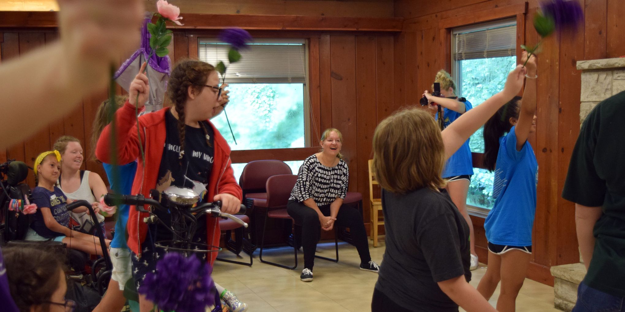 Deborah Sokol looks on as campers practice ballet with flowers in their hands