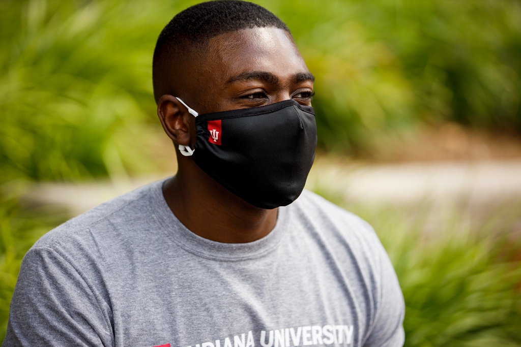 An IU student wears a black IU-branded mask