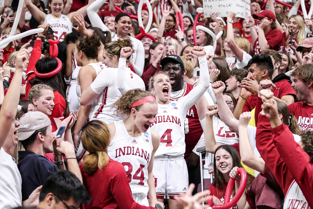 Indiana women's basketball players celebrate a victory with fans