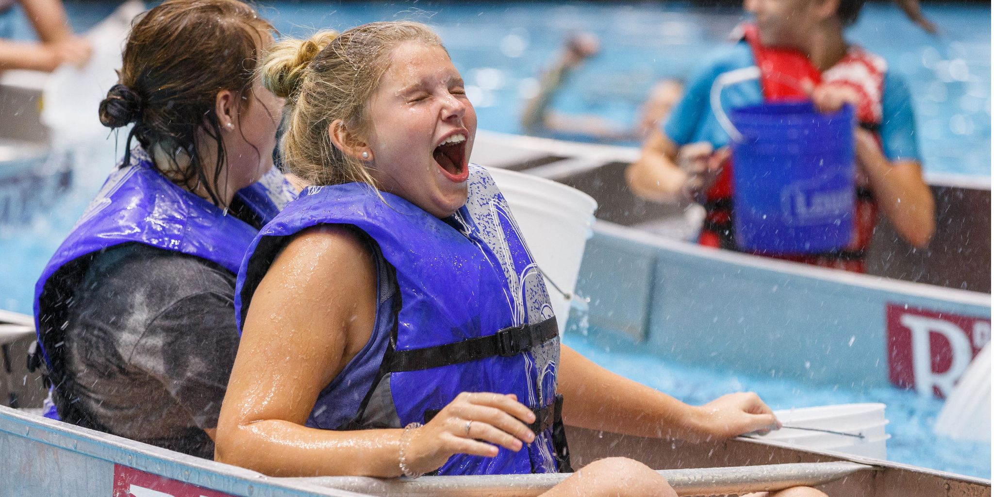 A student reacts to being splashed in a canoe.