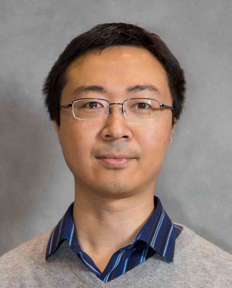 Yueyu Fu in front of a gray background.