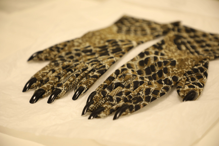 A pair of python-patterned gloves with black fingernails