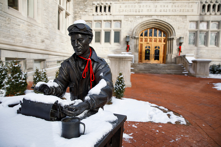 A statue of Ernie Pyle covered in snow on the IU Bloomington campus