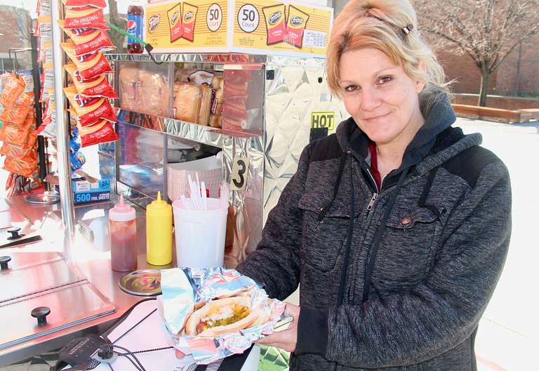 Melissa Pratt displays a hot dog at her cart.
