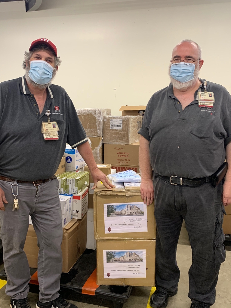 IU Health employees wearing masks and standing next to boxes of donated masks