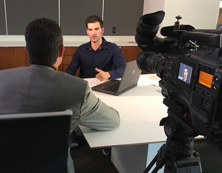 IU student Nikos Potamousis explains the camp safety reporting project to WTHR-TV