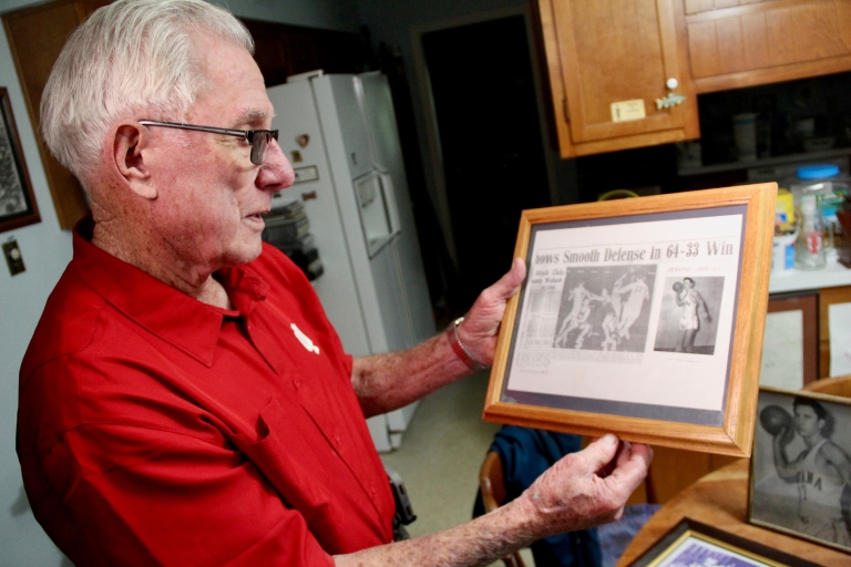 Christie looks at a framed newspaper clipping.