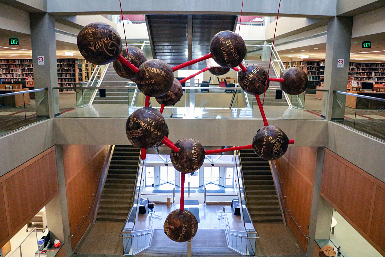 a molecule-like sculpture hangs in the IUPUI University Library