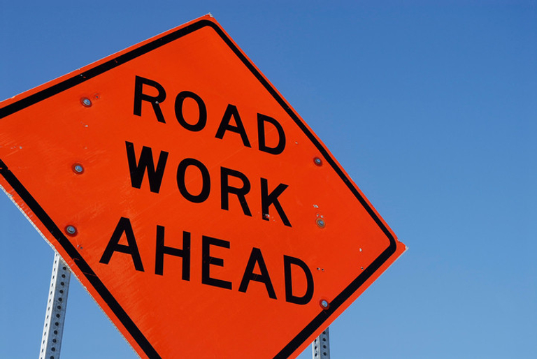 A construction sign that reads 'Road Work Ahead'