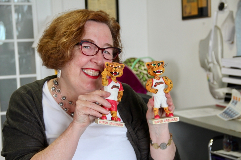 a woman holds two jaguar bobbleheads