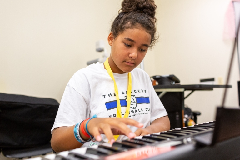 A girl plays an electronic keyboard.