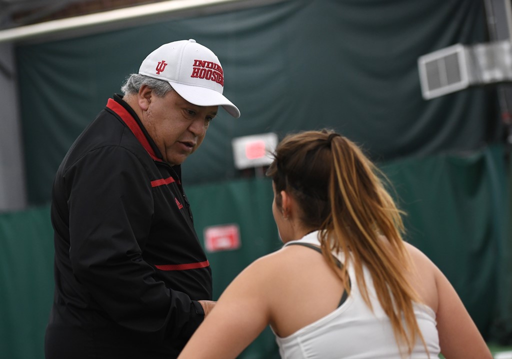 Ramiro Azcui speaks to a women's tennis player