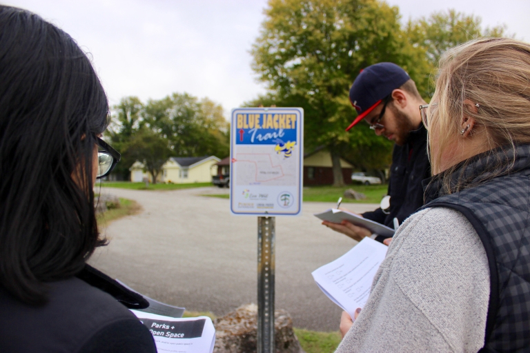 Students take notes at a trail sign.
