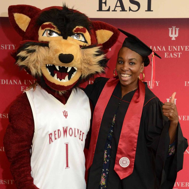 IU East's Red Wolves mascot stands with tennis pro Venus Williams at a commencement ceremony.