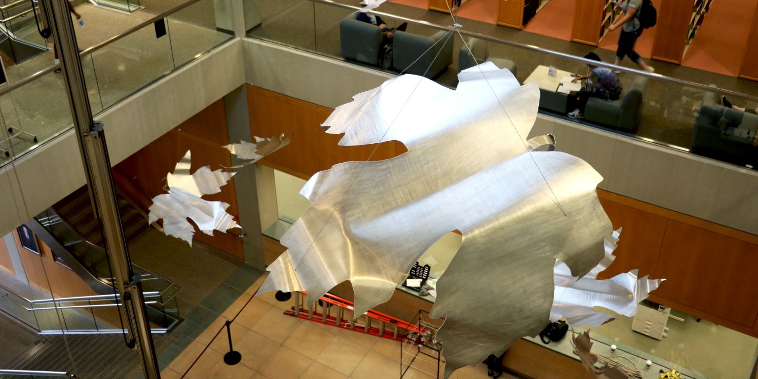 Large silver leaves hang in the University Library atrium