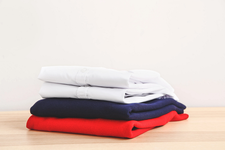 School uniforms sit folded on a table.