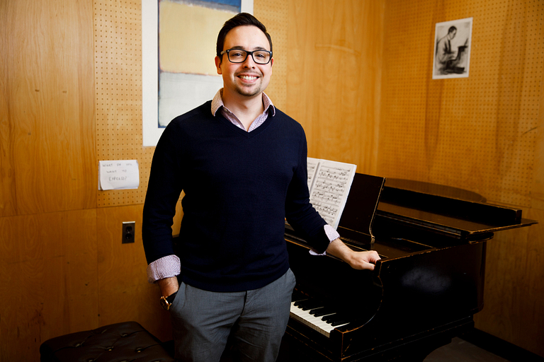 Dominic Muzzi stands by piano