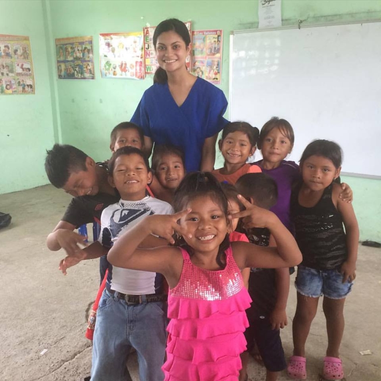 Amna Sohail stands with a group of young children at a health clinic in Panama.