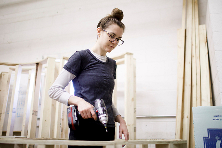 Amanda Waterhouse uses an electronic screwdriver while working on her large-scale sculpture. 