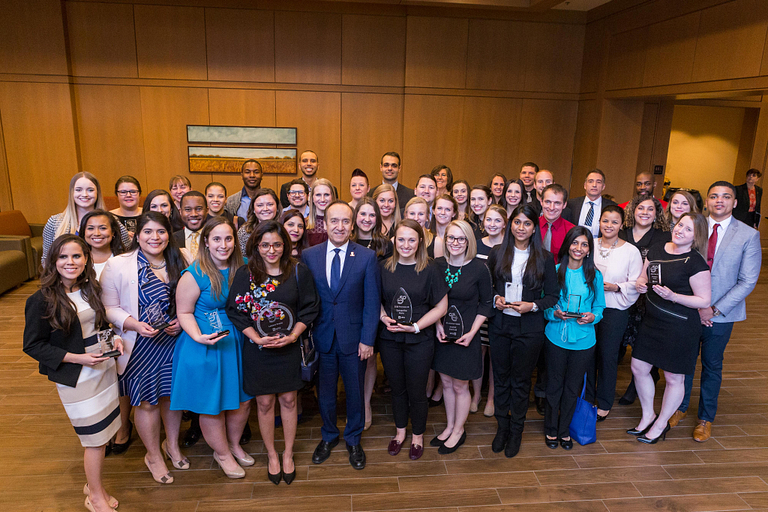 A group of students pose at an awards ceremony.