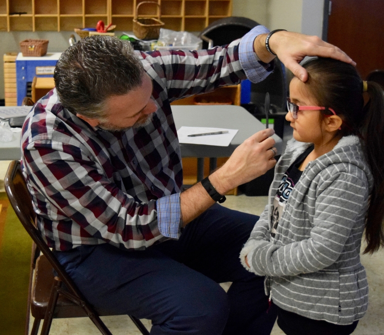 Don Lyon of the IU School of Optometry performs an eye exam.