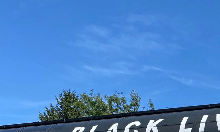 An anti-discrimination banner hangs from the Michigan and Blake streets walkway