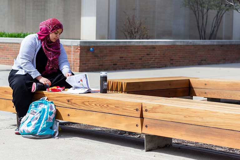 A student studies on a new bench on-campus.