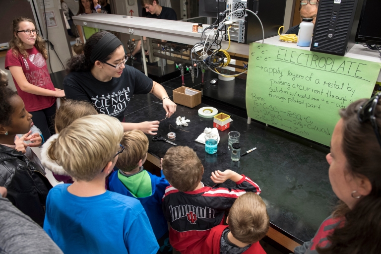 An IU student demonstrates electroplating to kids at IU Science Fest.