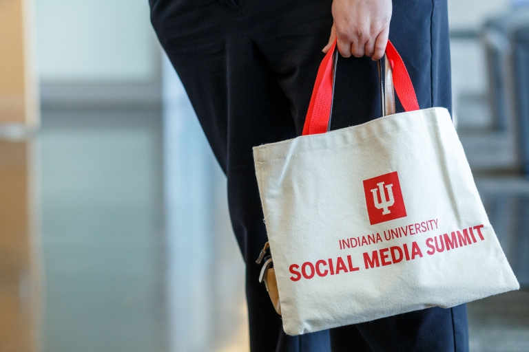 A person holds a bag that reads Indiana University Social Media Summit
