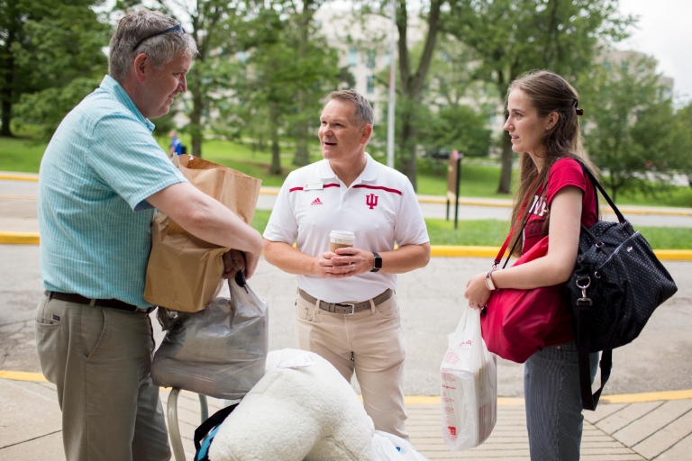 David Johnson talks to a student and a parent as they move in